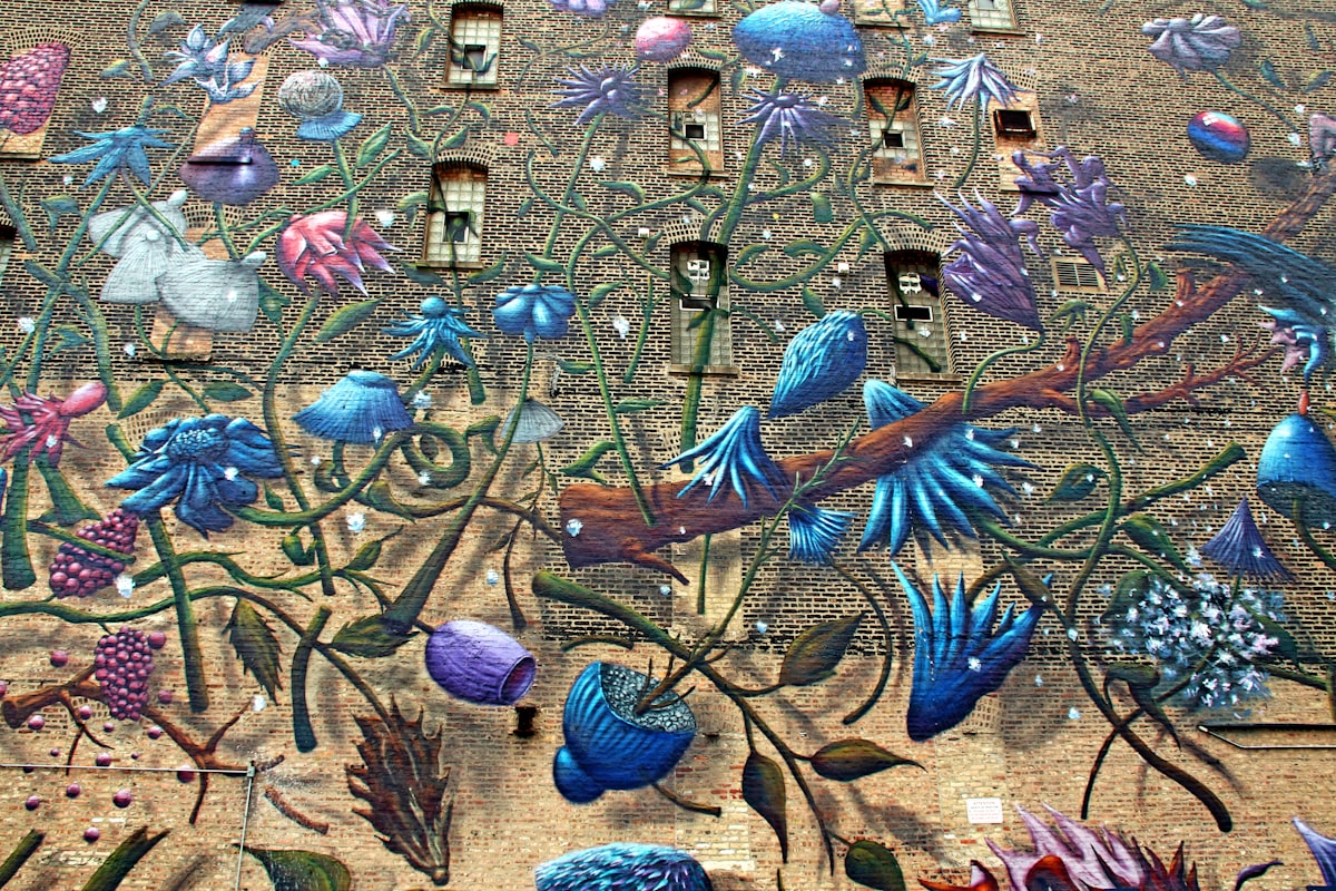 A colorful mural of birds and flowers on a brick wall