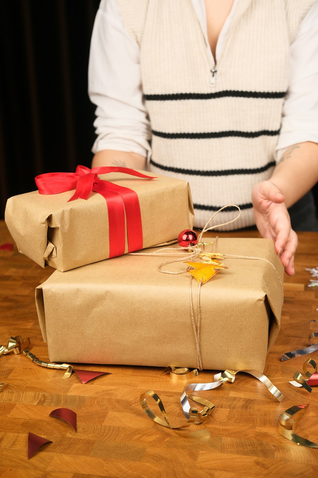 Two wrapped gifts with red ribbon and confetti