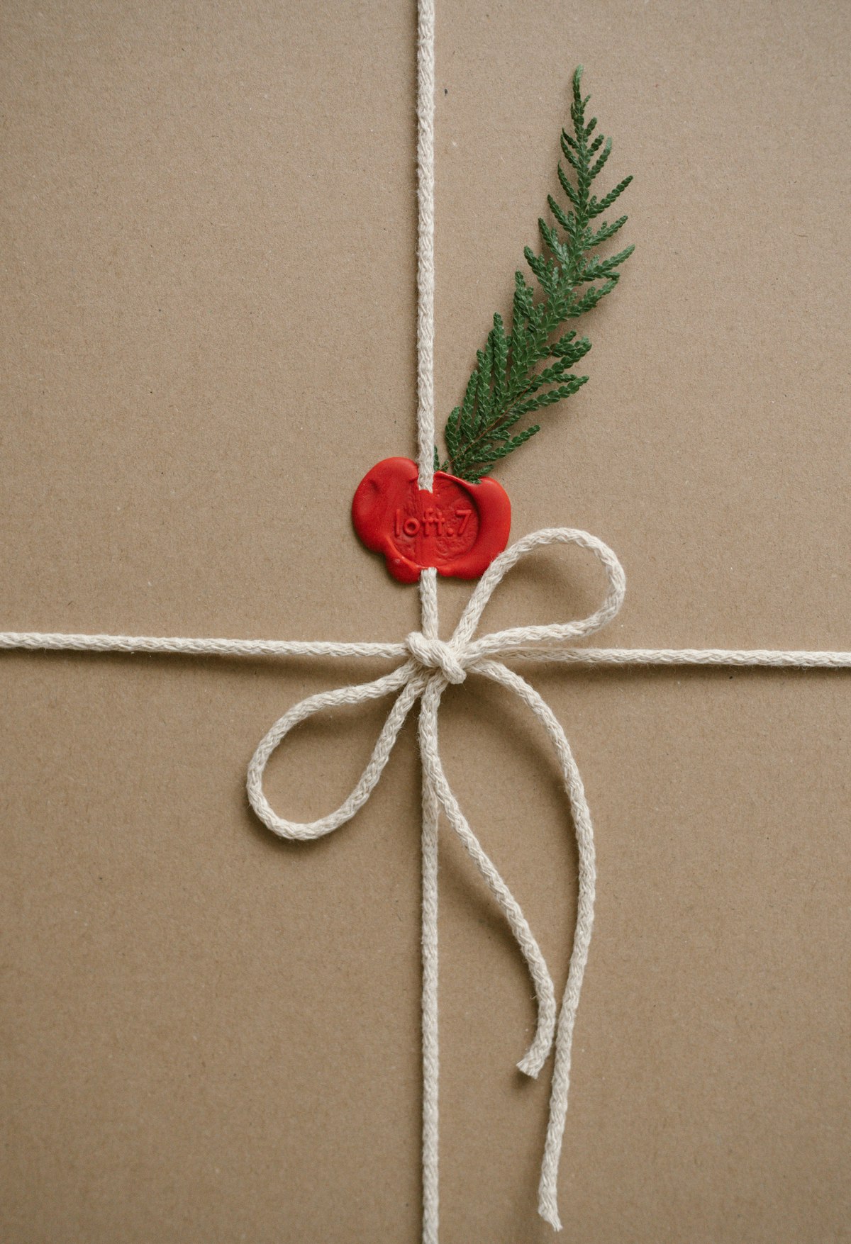 A brown paper package tied with white string and a red wax seal