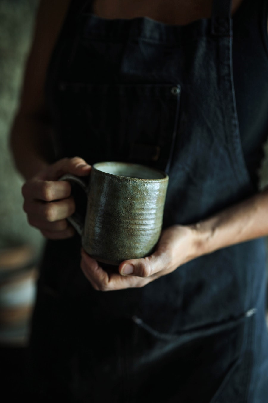 A person holding a ceramic mug