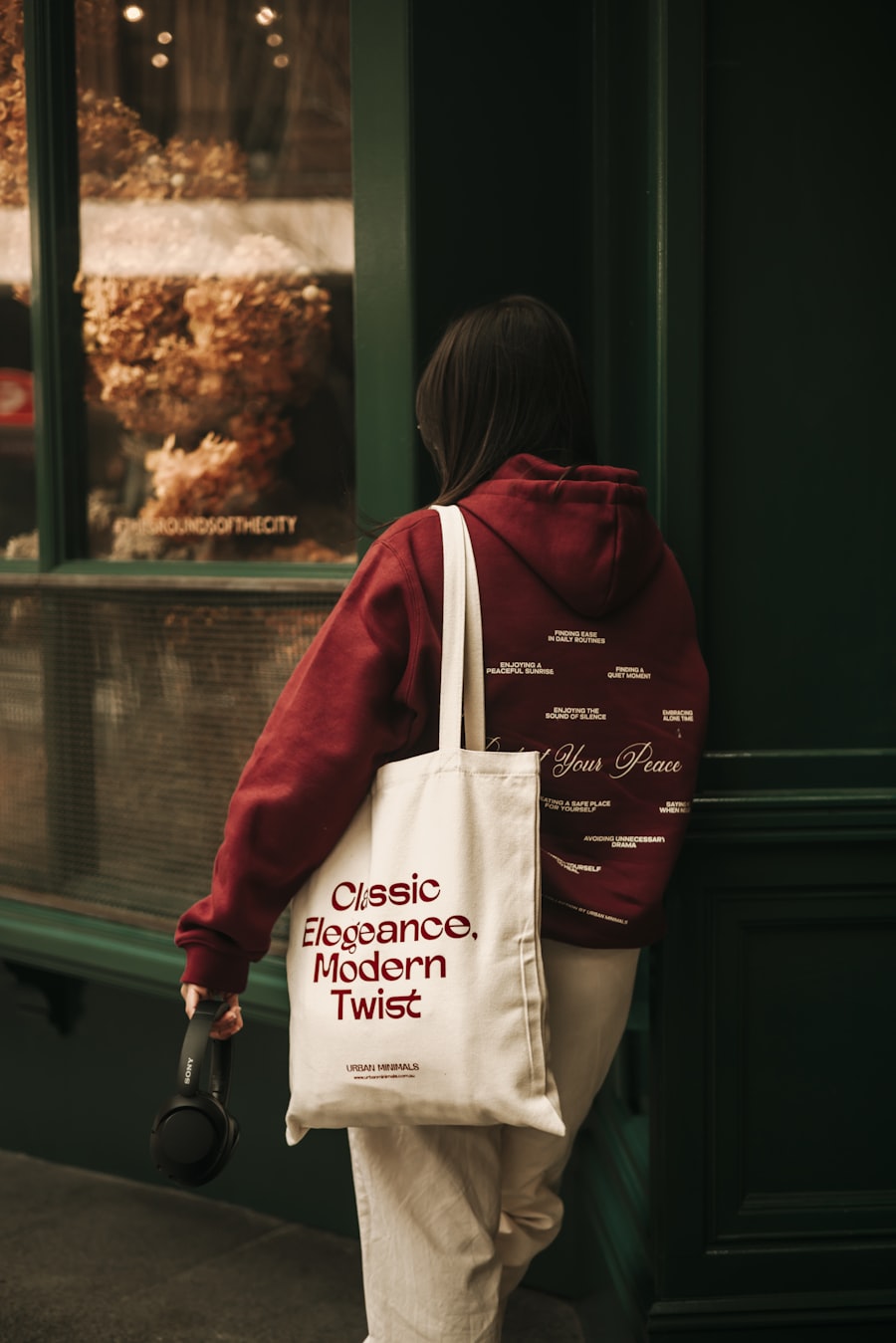 A woman walking down a street carrying a tote bag
