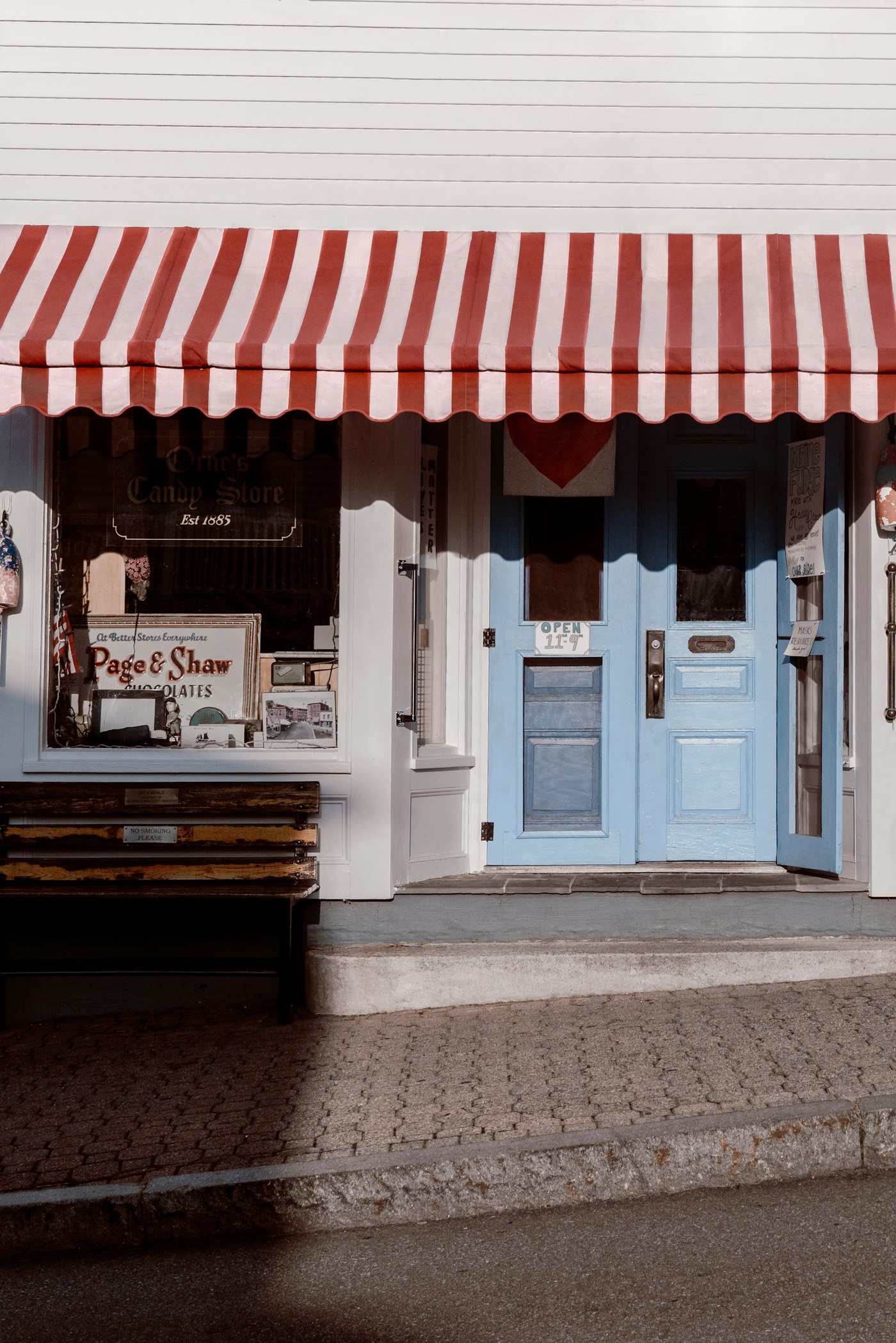 A white and red neighborhood storefront on a sunny day